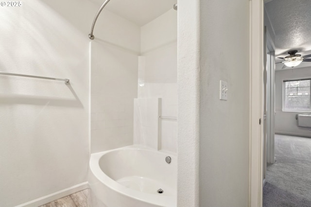 bathroom featuring a textured ceiling, shower / bathtub combination, and ceiling fan