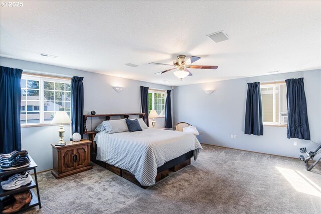 bedroom with multiple windows, carpet, ceiling fan, and visible vents