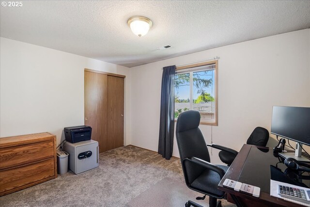 carpeted office space featuring a textured ceiling and visible vents