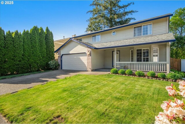traditional-style home featuring fence, covered porch, a front yard, an attached garage, and driveway