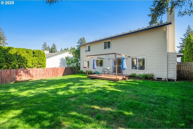 rear view of house featuring a pergola, a wooden deck, a fenced backyard, a chimney, and a lawn