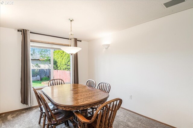 carpeted dining space with baseboards