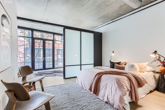 bedroom featuring expansive windows and wood finished floors