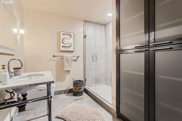 bathroom with a sink, baseboards, and a stall shower