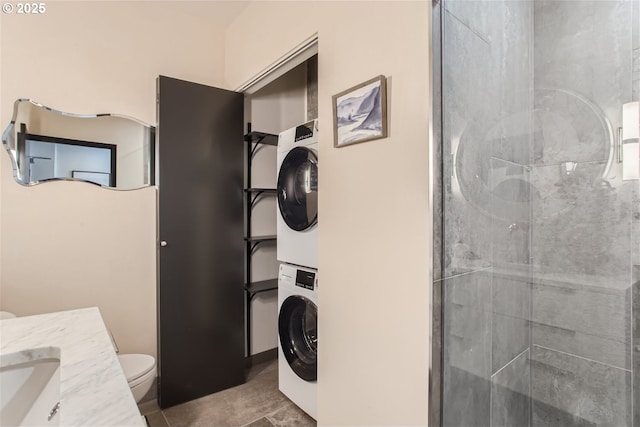 clothes washing area featuring laundry area, stacked washer / dryer, and tile patterned floors