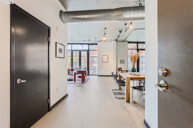 hall with expansive windows and wood finished floors