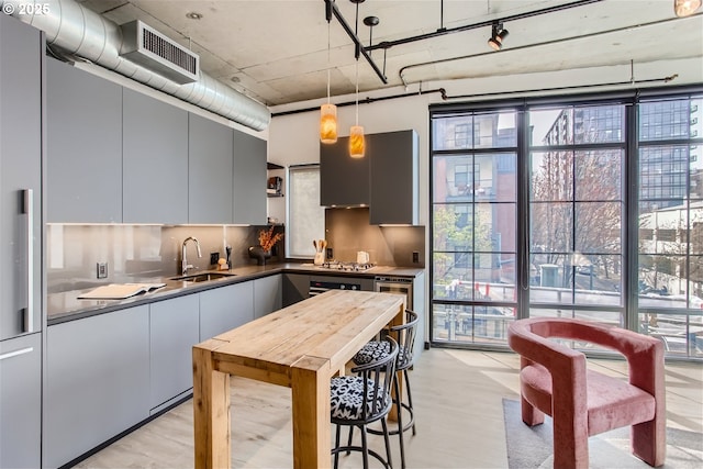 kitchen with visible vents, decorative backsplash, dark countertops, modern cabinets, and a sink