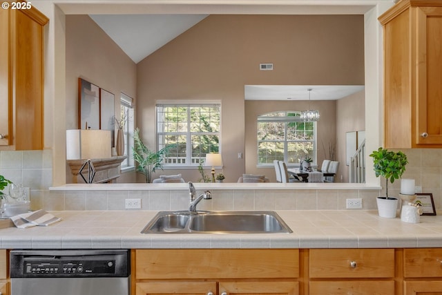 kitchen featuring tasteful backsplash, vaulted ceiling, dishwasher, sink, and an inviting chandelier