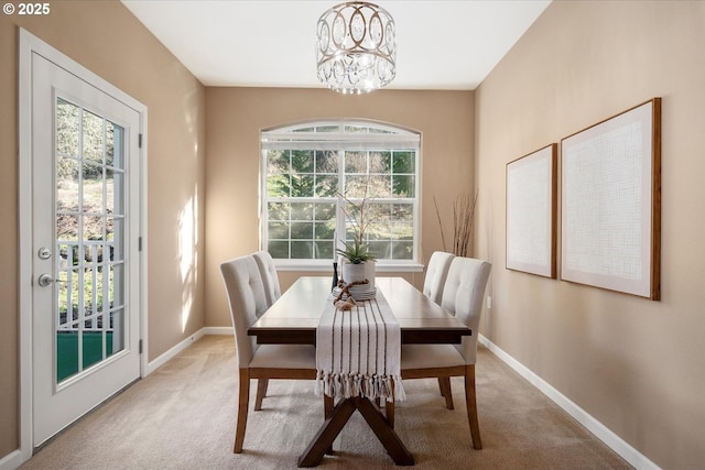 carpeted dining area featuring a chandelier