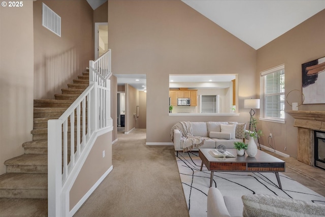 living room featuring high vaulted ceiling and light colored carpet