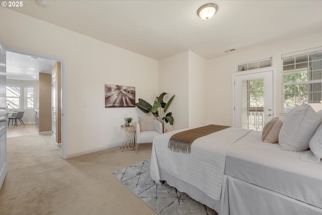 carpeted bedroom featuring access to outside and multiple windows