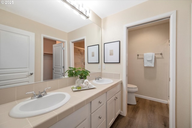 bathroom with toilet, hardwood / wood-style flooring, and vanity