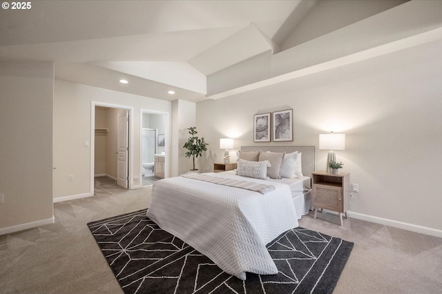 bedroom with a spacious closet, light colored carpet, connected bathroom, and lofted ceiling