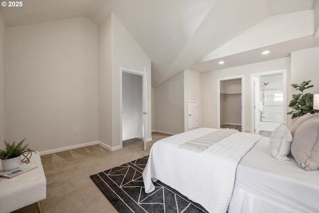 bedroom with carpet, ensuite bathroom, lofted ceiling, a walk in closet, and a closet