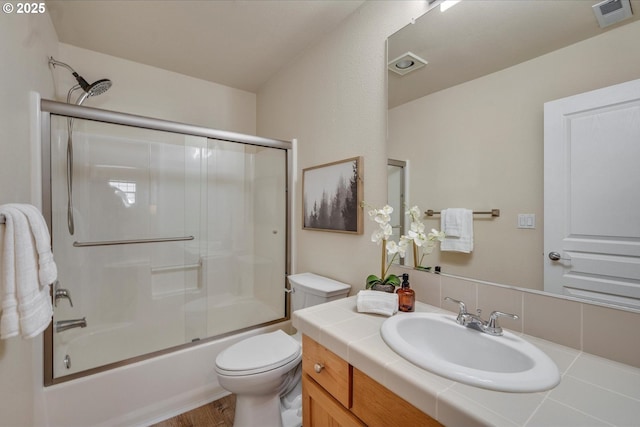 full bathroom featuring enclosed tub / shower combo, wood-type flooring, vanity, decorative backsplash, and toilet