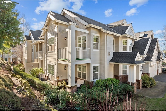 view of side of home featuring a balcony and central AC