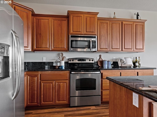 4257 SE Jetty Ave, Lincoln City, OR 97367 - kitchen with dark stone counters, appliances with stainless steel finishes, dark wood finished floors, and brown cabinets