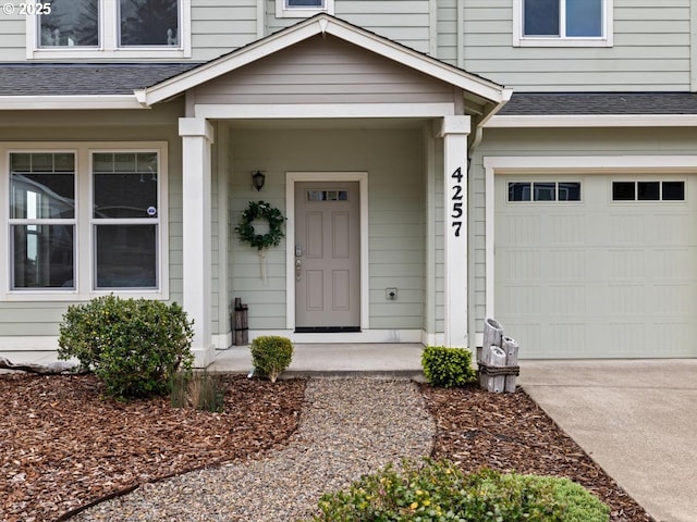 4257 SE Jetty Ave, Lincoln City, OR 97367 - entrance to property featuring concrete driveway, a shingled roof, an attached garage, and covered porch