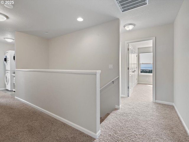 4257 SE Jetty Ave, Lincoln City, OR 97367 - hall with an upstairs landing, carpet, stacked washer and clothes dryer, and visible vents