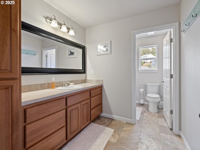 4257 SE Jetty Ave, Lincoln City, OR 97367 - bathroom with stone finish flooring, vanity, toilet, and baseboards
