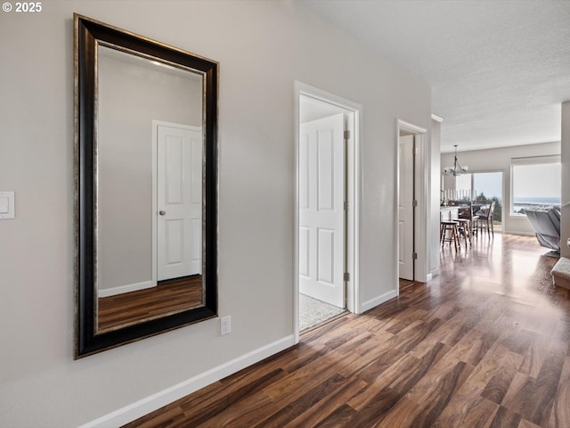4257 SE Jetty Ave, Lincoln City, OR 97367 - hall featuring dark wood-style flooring, a chandelier, and baseboards