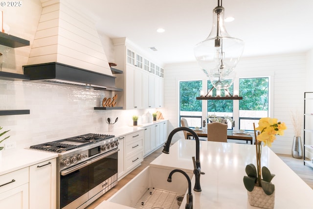 1931 13th St, West Linn, OR 97068 - kitchen with high end stainless steel range, decorative backsplash, white cabinetry, open shelves, and light countertops
