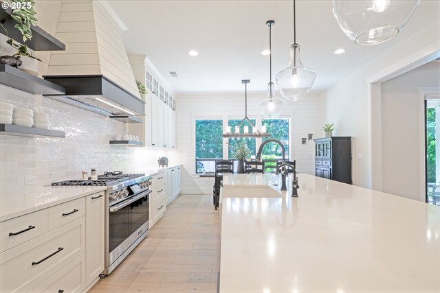 1931 13th St, West Linn, OR 97068 - kitchen featuring high end range, open shelves, a chandelier, light wood-style flooring, and backsplash