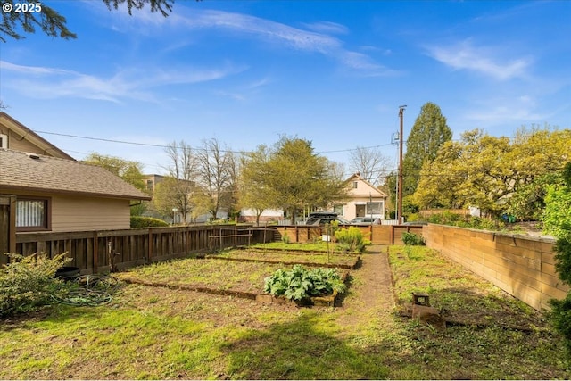 view of yard featuring a garden and a fenced backyard