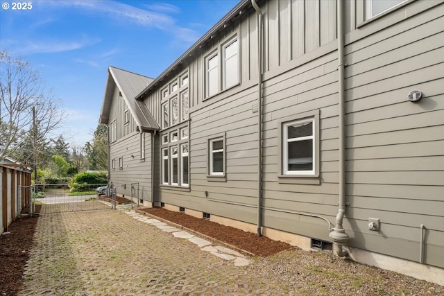 view of home's exterior featuring board and batten siding and fence