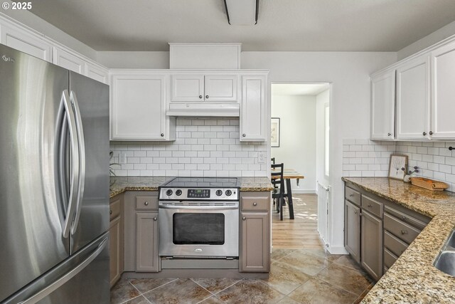 kitchen featuring appliances with stainless steel finishes, under cabinet range hood, decorative backsplash, and white cabinets
