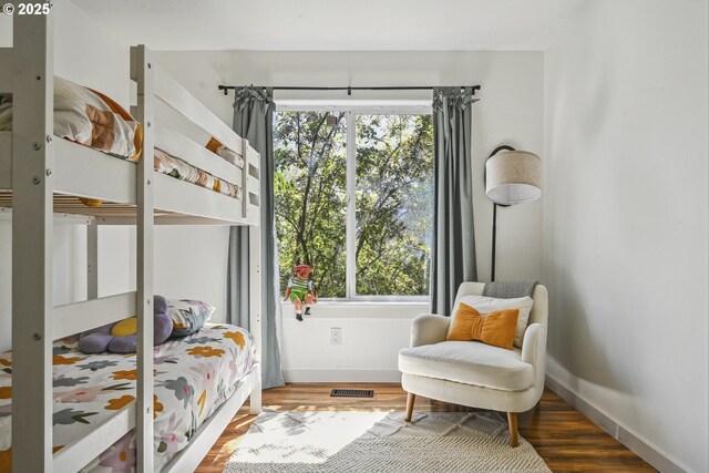 bedroom with wood finished floors and baseboards