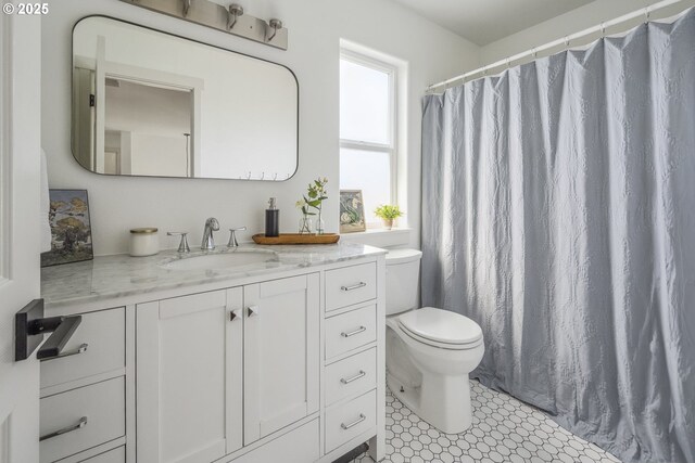 bathroom featuring toilet, vanity, and a shower with shower curtain