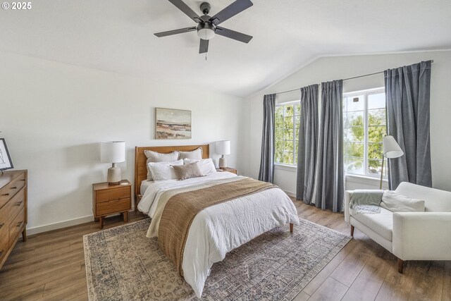 bedroom featuring lofted ceiling, wood finished floors, ceiling fan, and baseboards