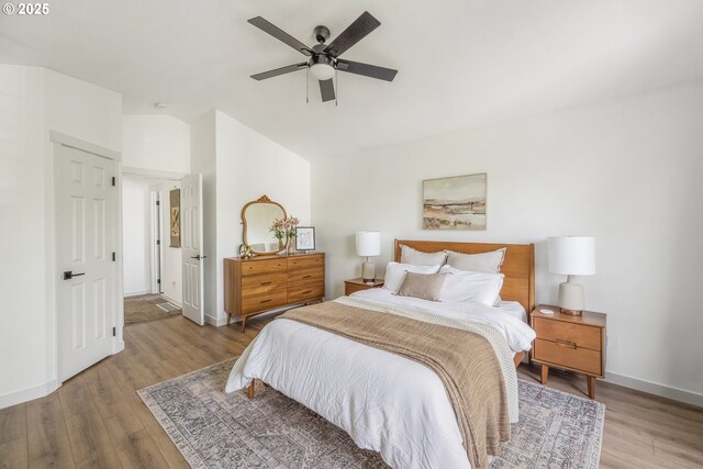 bedroom with lofted ceiling, wood finished floors, baseboards, and ceiling fan