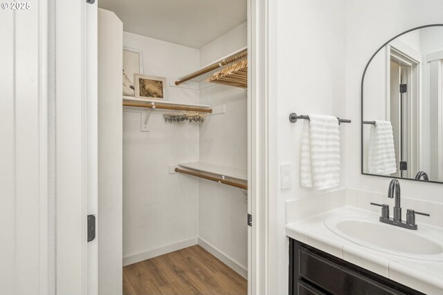 bathroom with wood finished floors, vanity, and baseboards