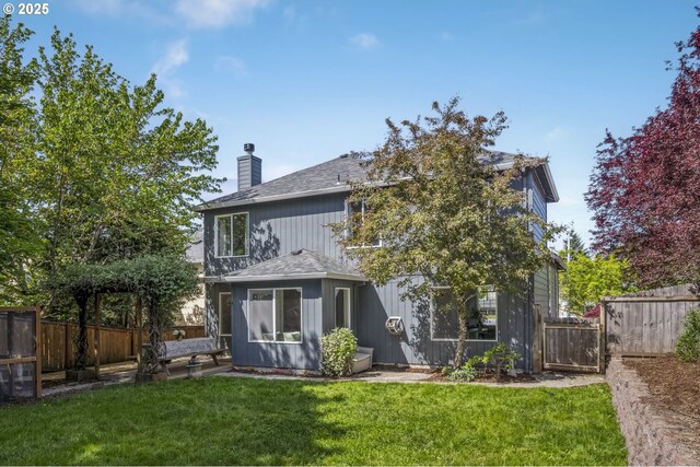back of property featuring a shingled roof and a chimney