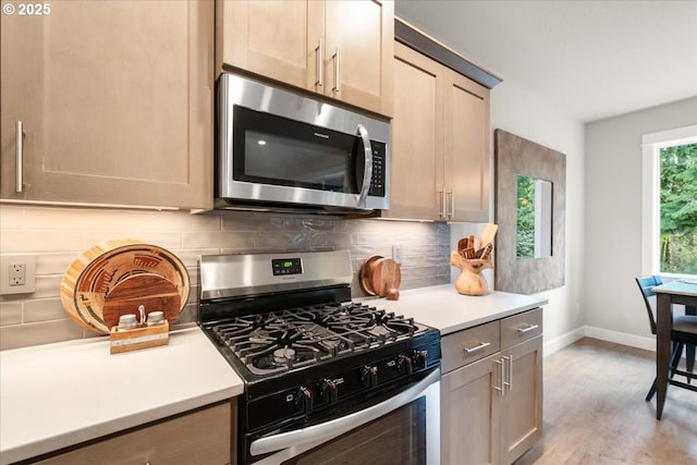 kitchen with light countertops, light wood-style floors, backsplash, and stainless steel appliances