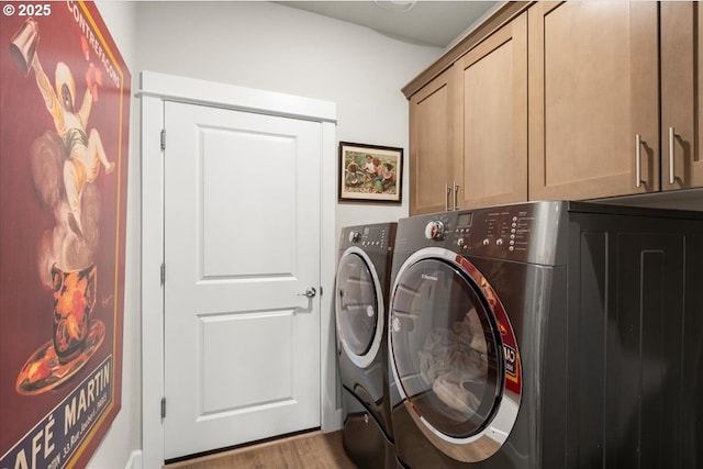 washroom with cabinet space, wood finished floors, and separate washer and dryer