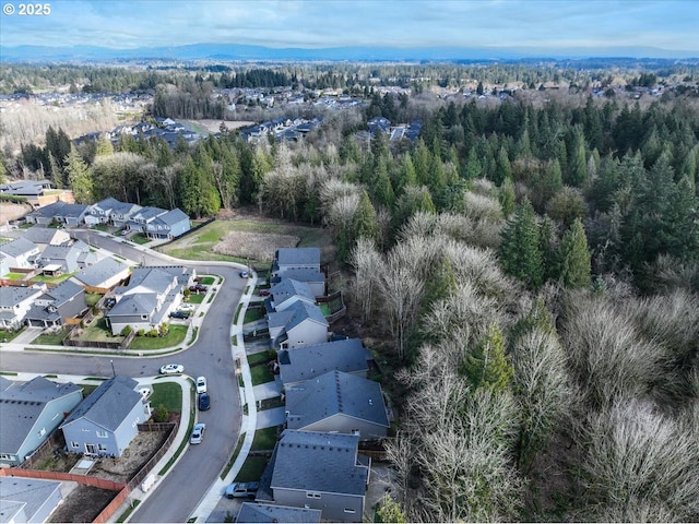 drone / aerial view featuring a residential view and a wooded view