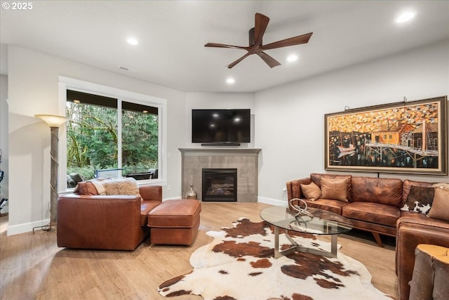 living room with recessed lighting, wood finished floors, a ceiling fan, and a tiled fireplace