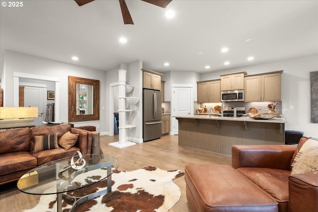 living area with recessed lighting, light wood-type flooring, and ceiling fan