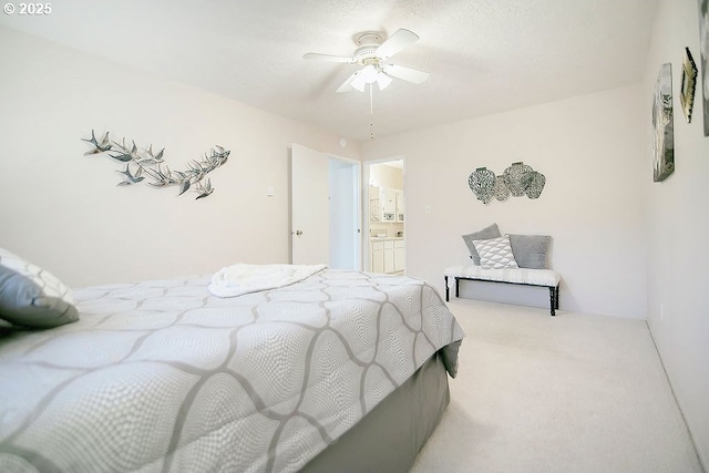 carpeted bedroom with ceiling fan and ensuite bath