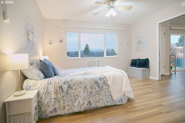 bedroom with ceiling fan, light hardwood / wood-style floors, and multiple windows