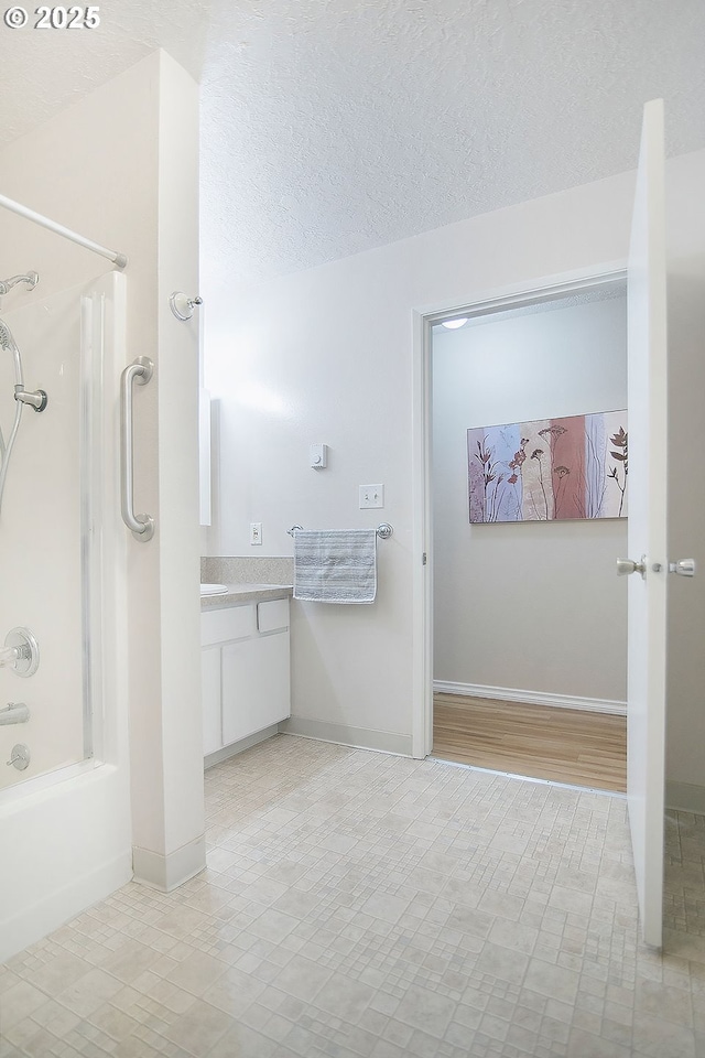 bathroom with vanity, tub / shower combination, and a textured ceiling