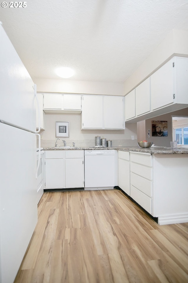 kitchen featuring white appliances, light hardwood / wood-style floors, sink, and white cabinets