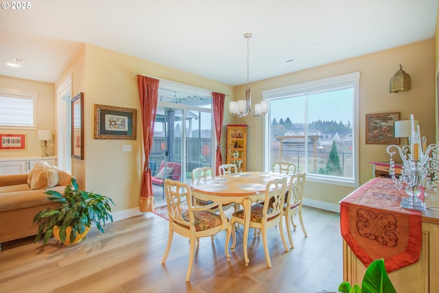 dining room with a notable chandelier and light hardwood / wood-style flooring