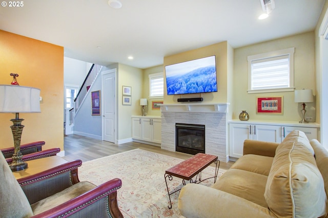 living room featuring a fireplace, light wood-type flooring, and a wealth of natural light