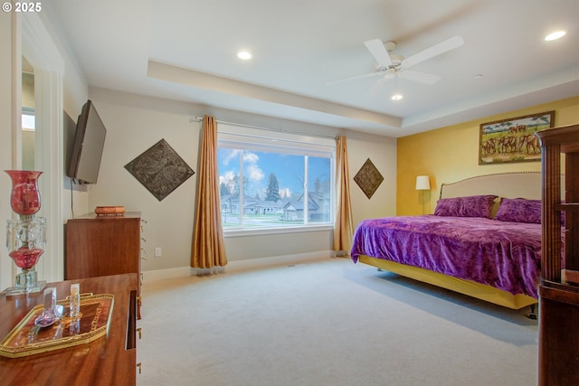 bedroom featuring a raised ceiling, carpet floors, and ceiling fan