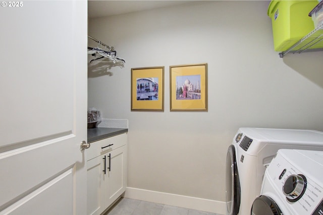 clothes washing area featuring cabinets, washing machine and clothes dryer, and light tile patterned floors