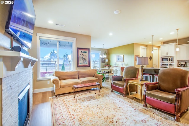 living room featuring light wood-type flooring and an inviting chandelier